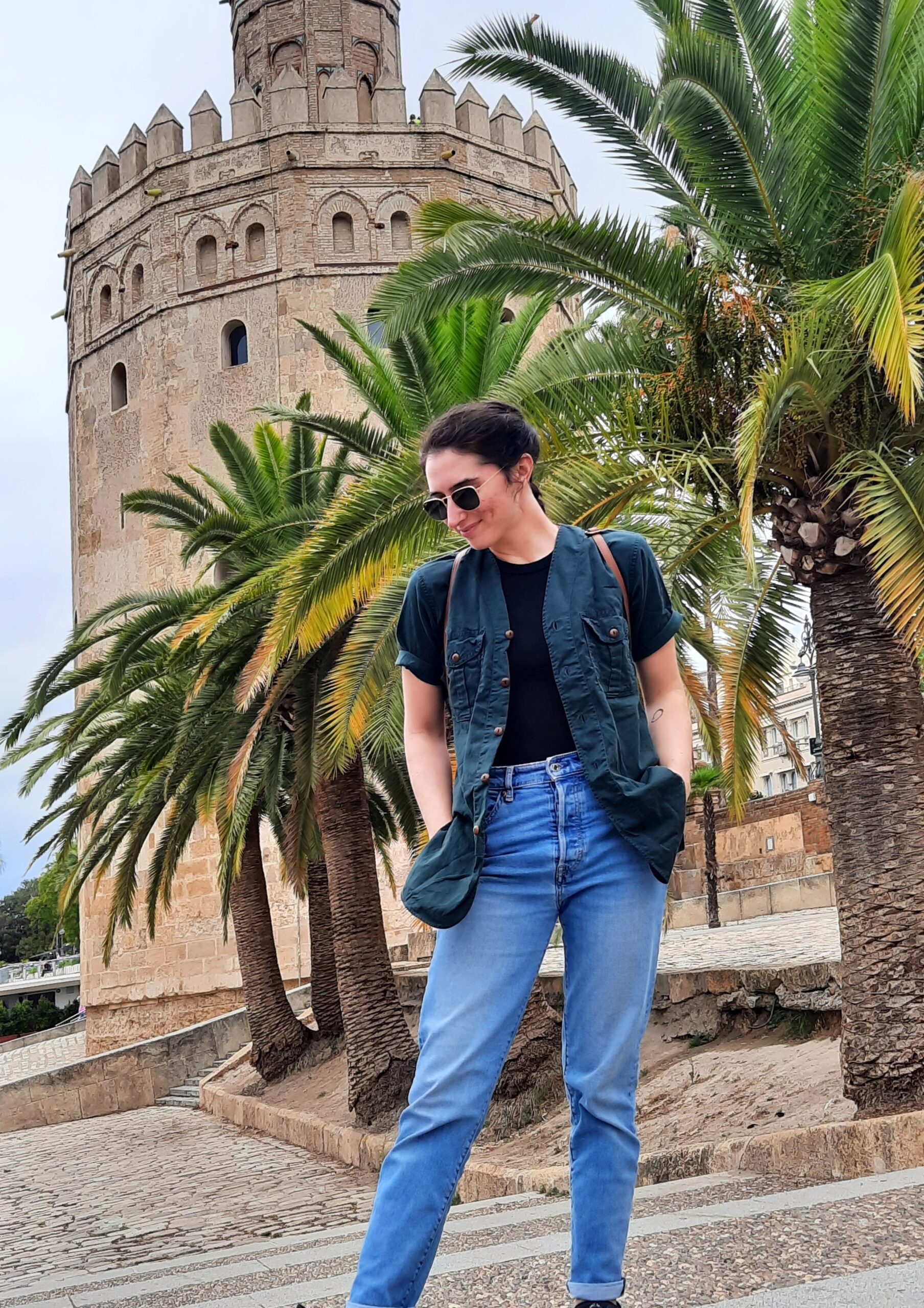 Young woman in front of Seville's Torre de oro.