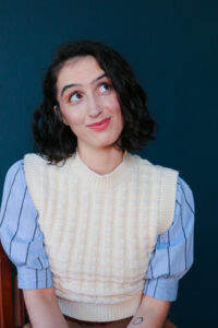 Woman in a white sweater looking up and smiling