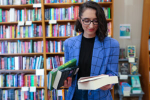 Young woman in blue blazer looking down at books