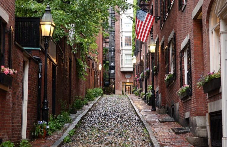 A narrow cobblestone street lined with brick buildings in Beacon Hill.